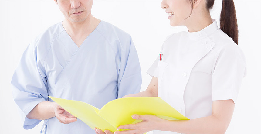女性看護師が男性に検査について説明をしている様子