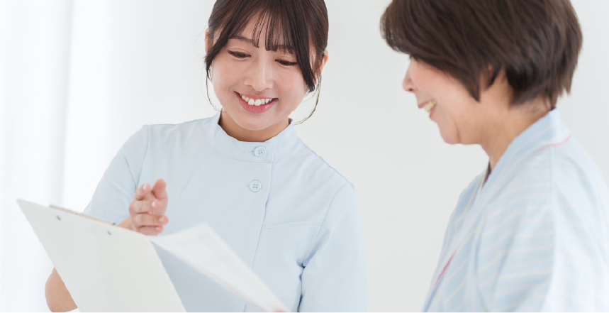 女性看護師が患者さまに検診の説明をしている様子