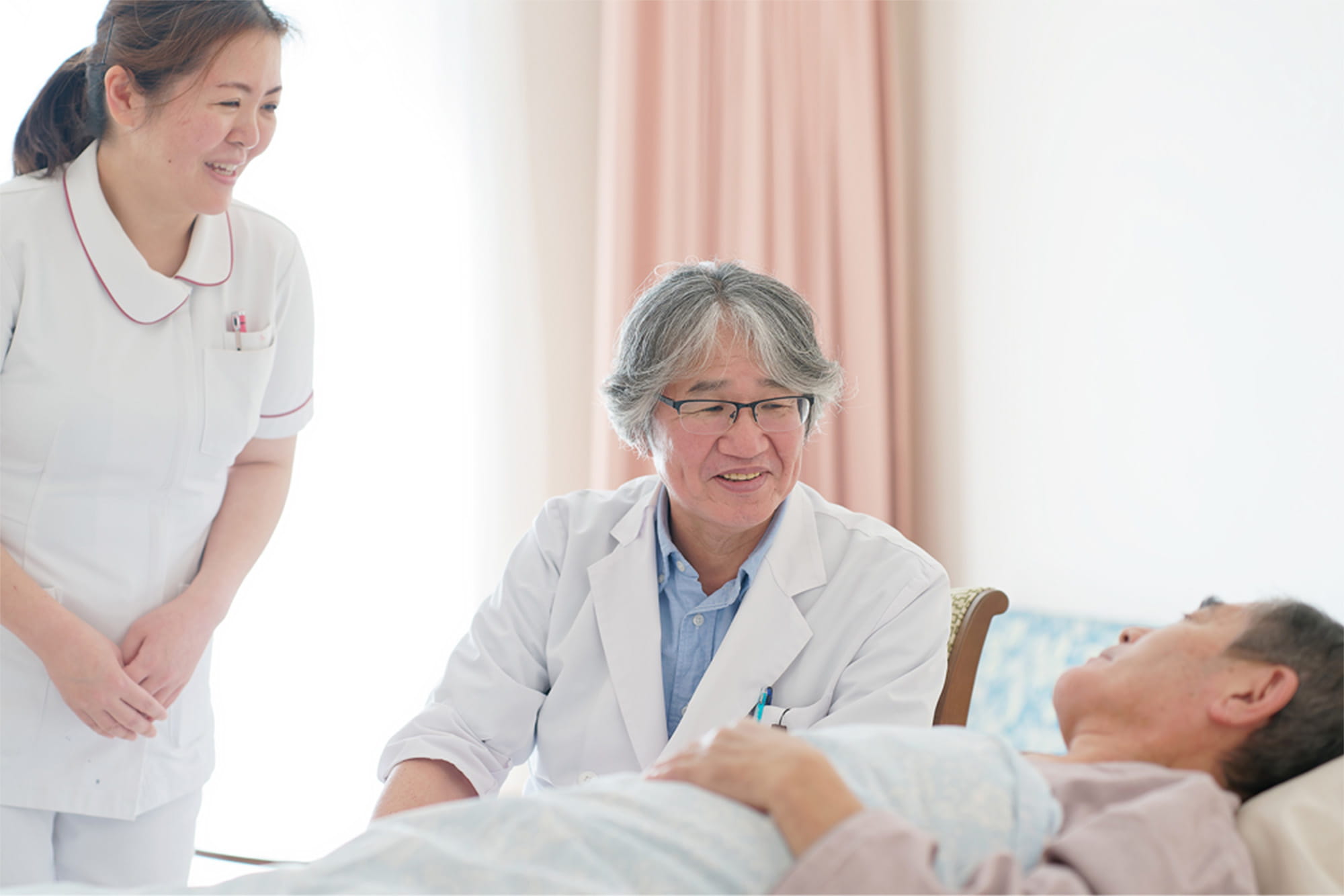 医師と看護師がベッドの男性と話をしている様子